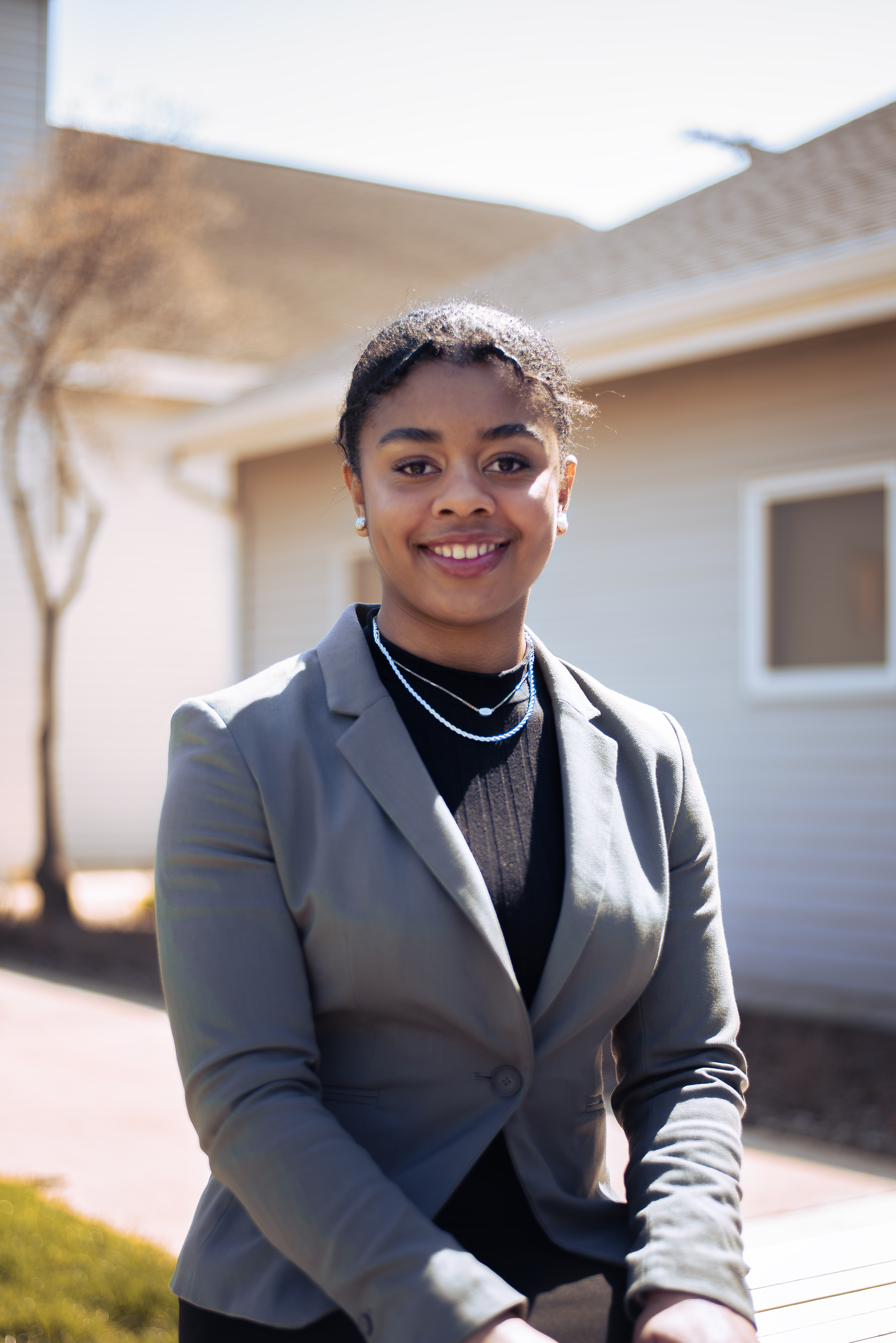 A young, warm honey-skinned Black woman in a professional suit